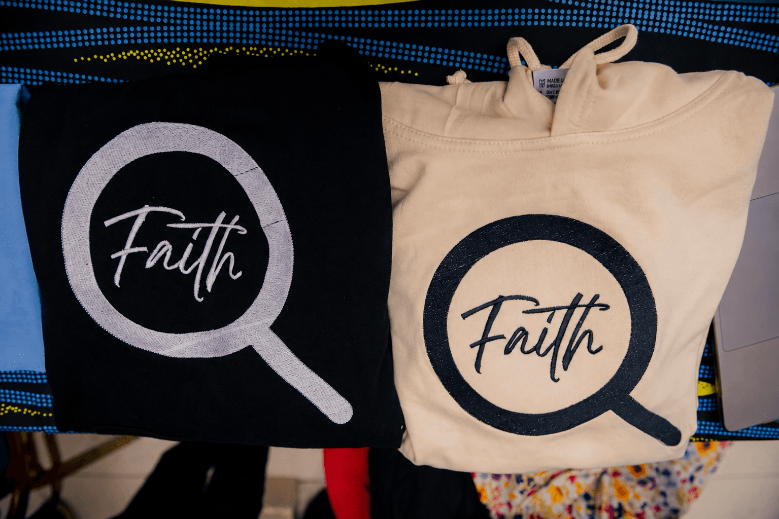 Black and cream FaithExplored hoodies displaying the Faith logo