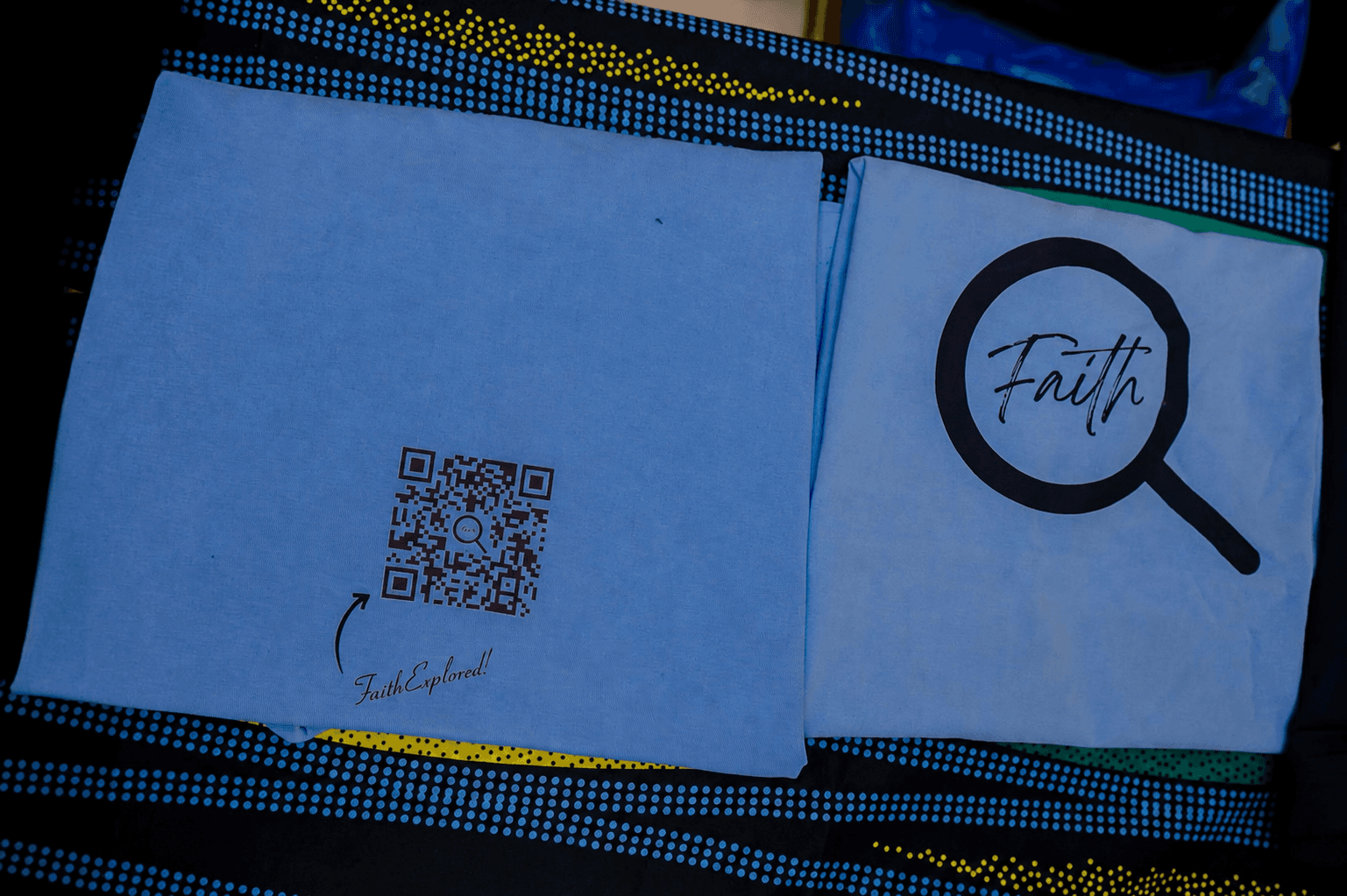 Sky blue FaithExplored T-shirts displaying the Faith logo and QR code