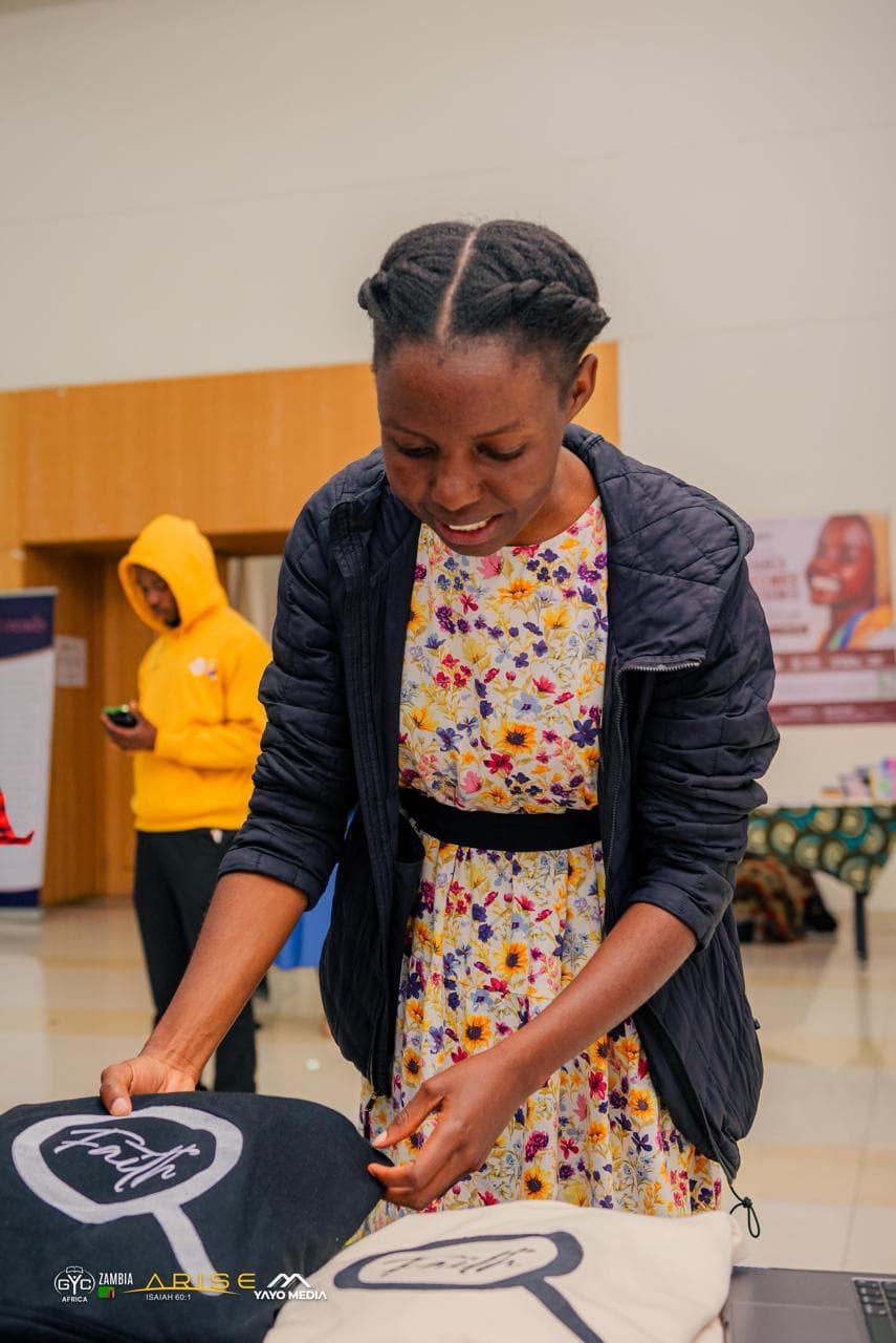 A woman arranging Faith clothing on the display table